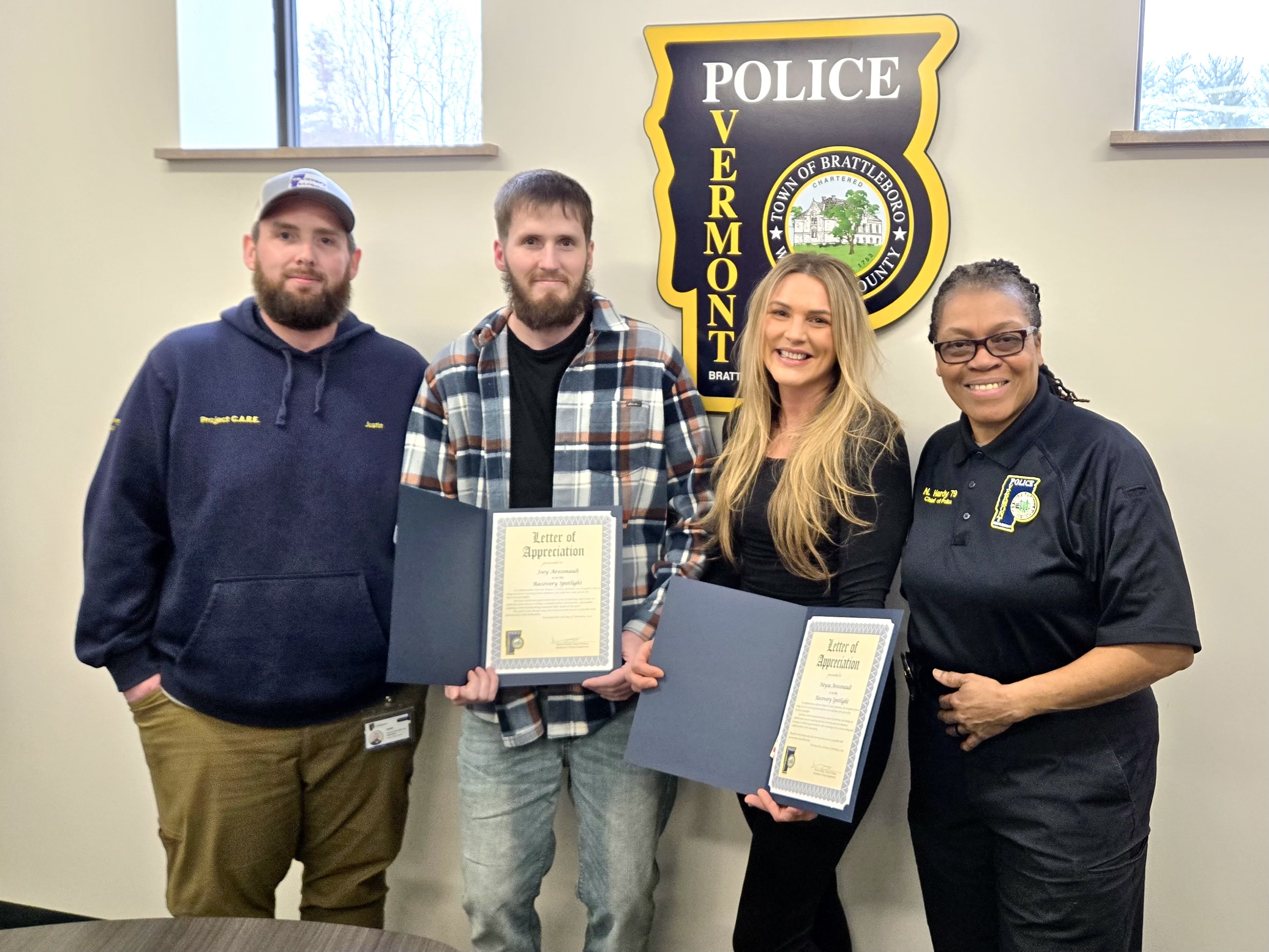 A photo of Justin Johnston and Chief Norma Hardy of the Brattleboro Police Department presenting an award to Neysa and Joey.